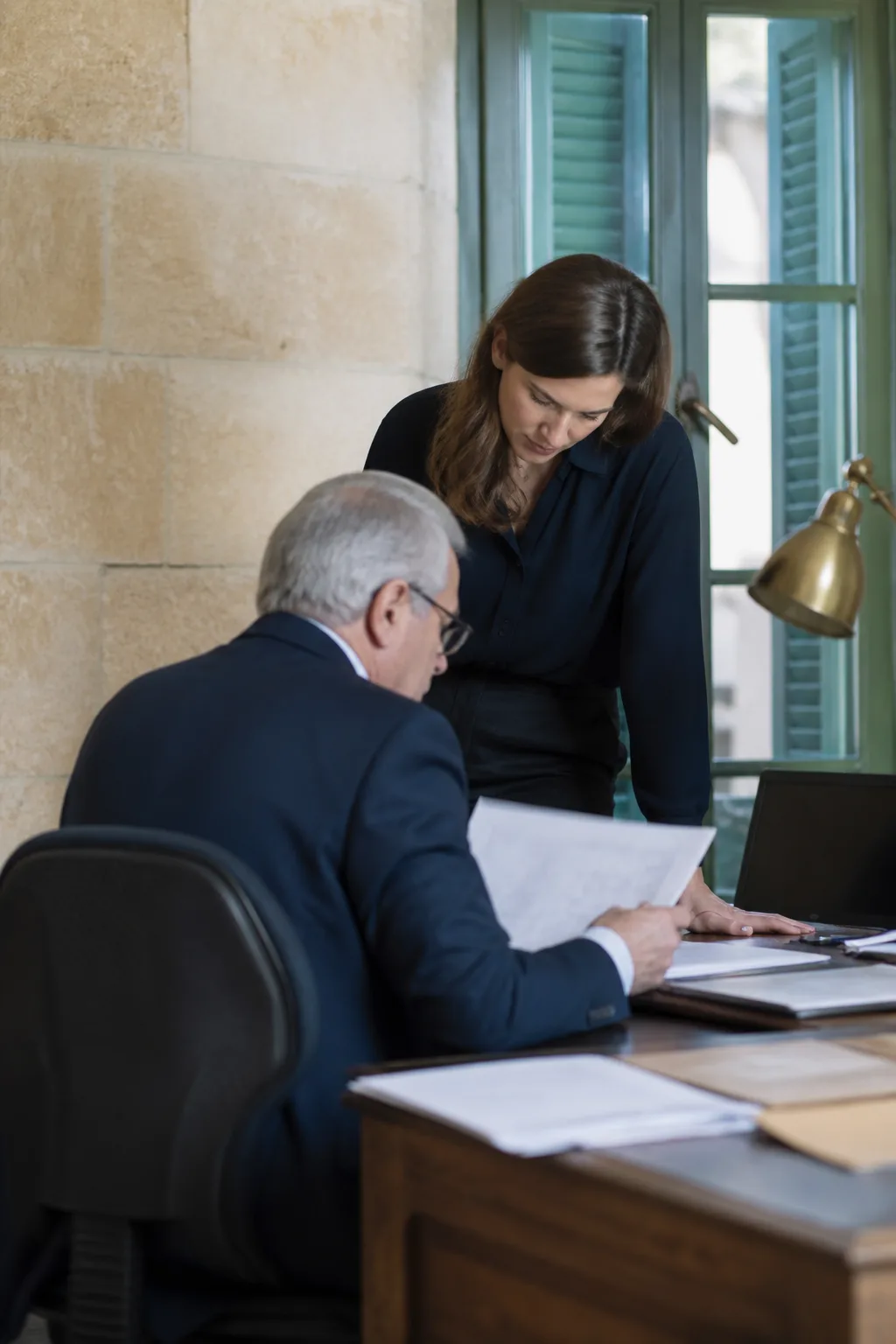 A senior accountant and colleague reviewing documents in a quiet Malta office