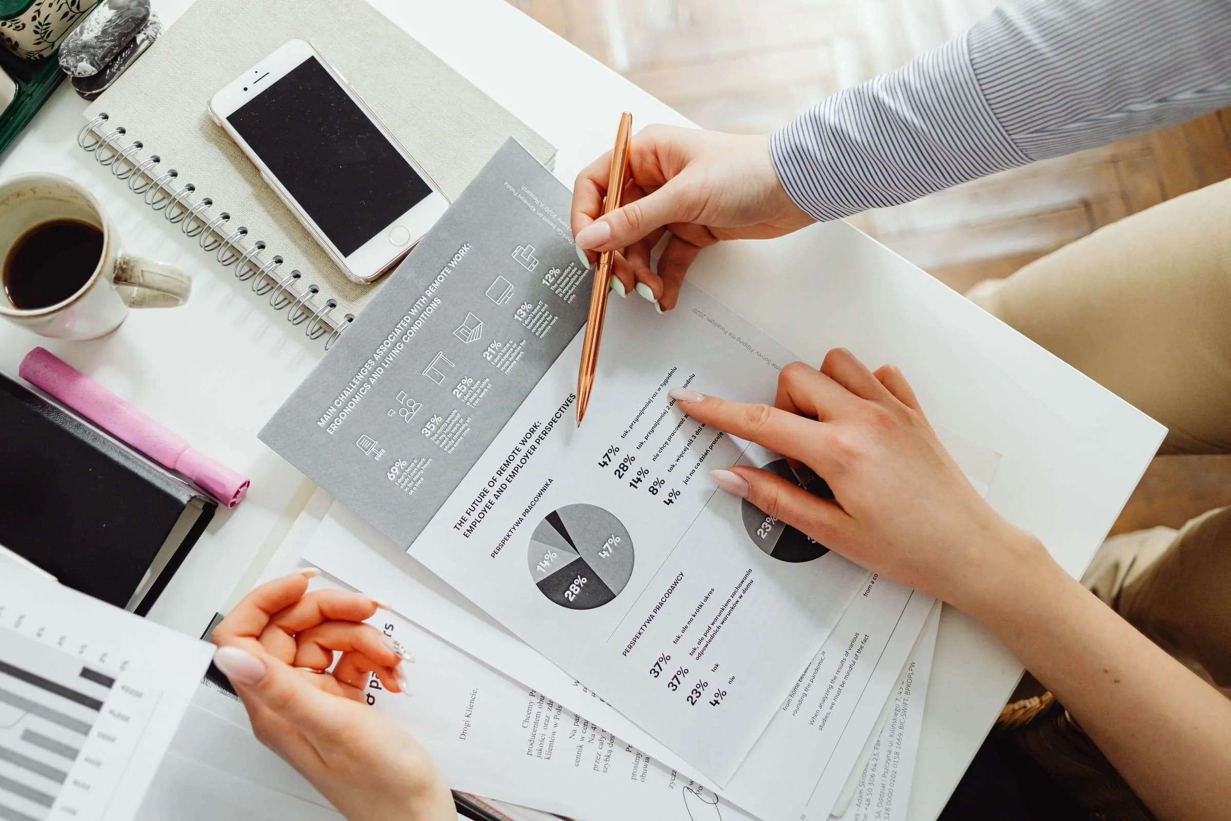 Two people reviewing printed financial charts at a desk