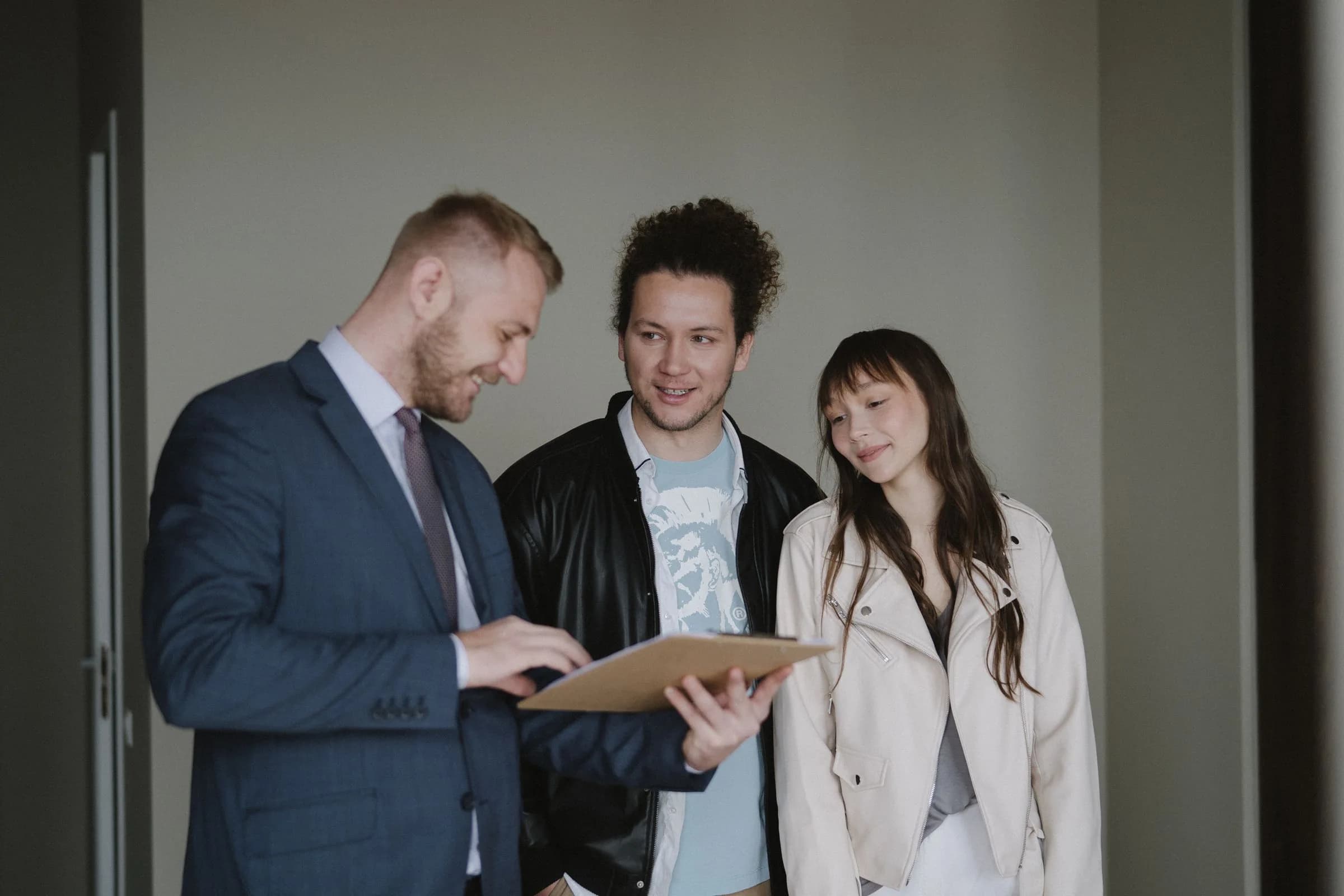An agent reviewing a document with two clients