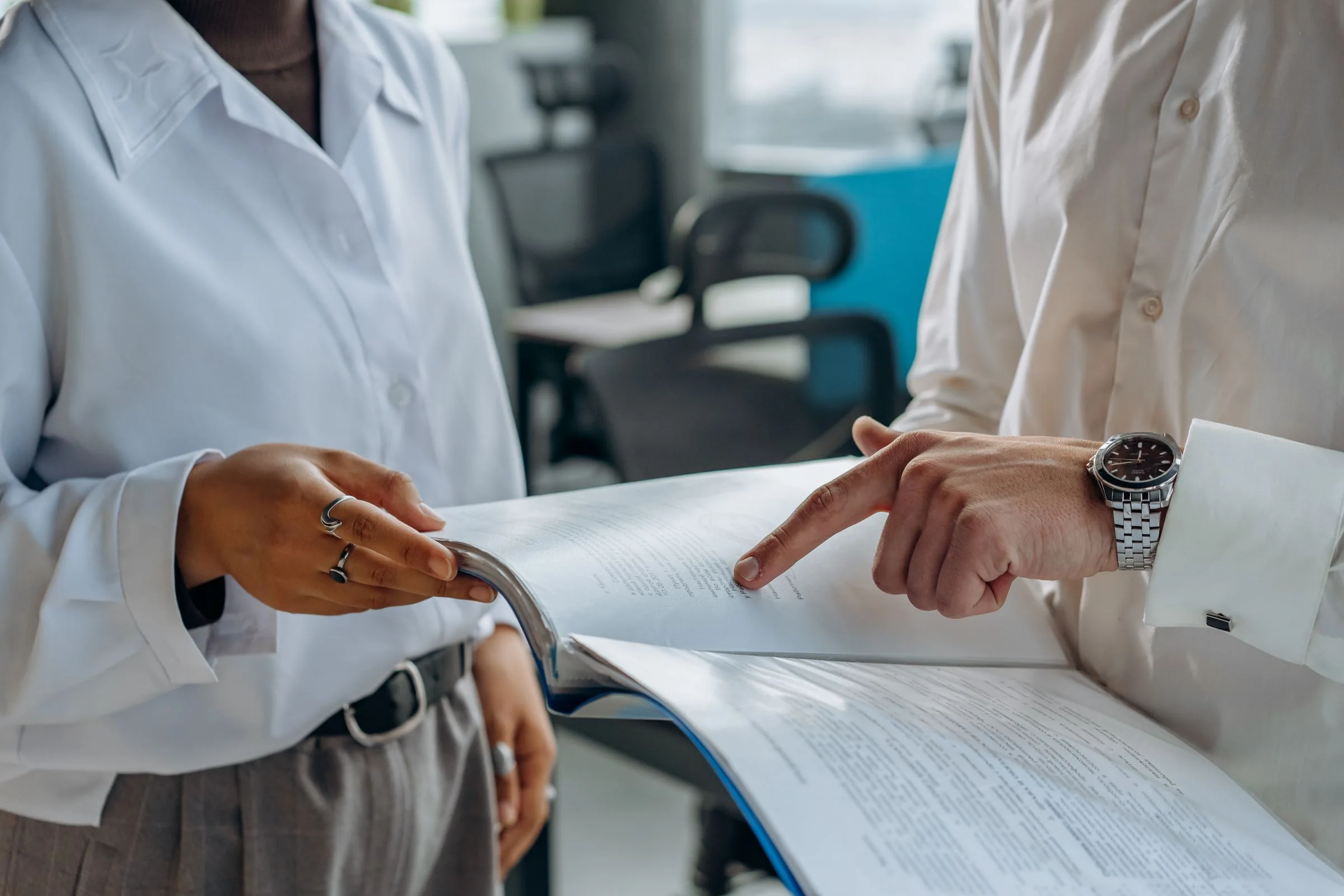 Two colleagues reviewing a printed financial report together