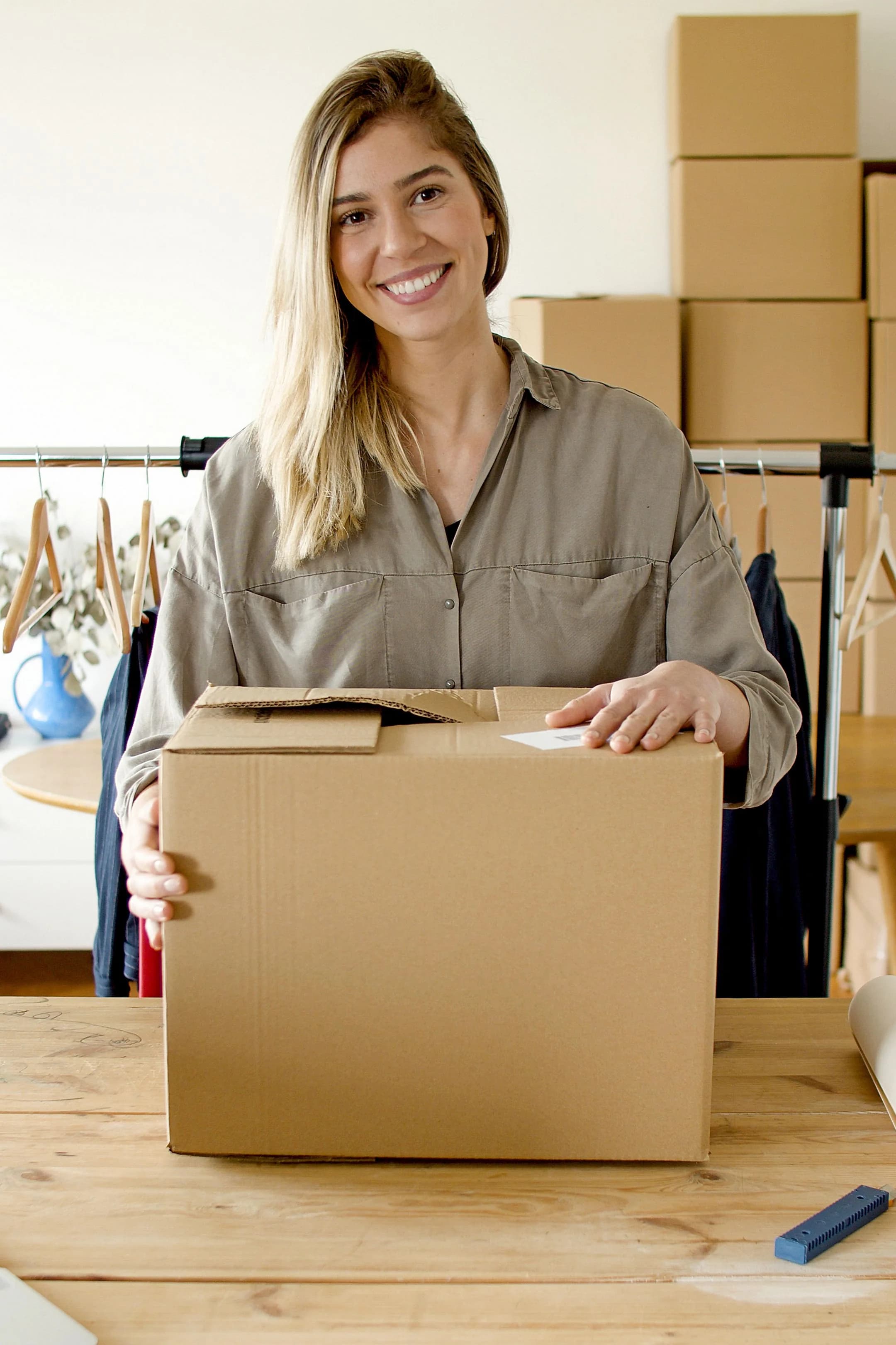 A small business owner holding a parcel in her clothing shop